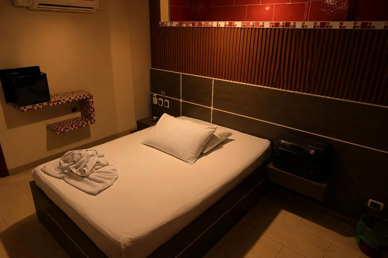 Habitación Sencilla en tonos rojos con parlante